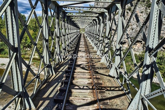 Steel Railway Bridge: Engineering & Landscape View Spanning a River