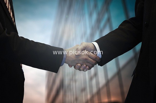 Business Professionals Shaking Hands in Collaboration: Symbol of Trust in Workplace Negotiations