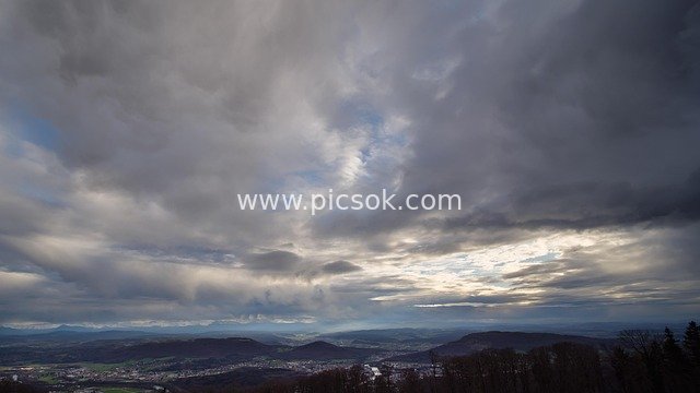 Distant Alpine Landscape at Dusk Under Rain Clouds