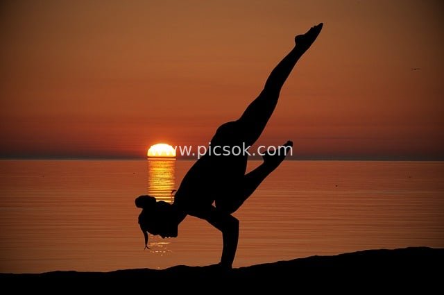 Yoga Silhouette by the Seaside at Sunset: A Beautiful Moment of Women’s Fitness & Relaxation