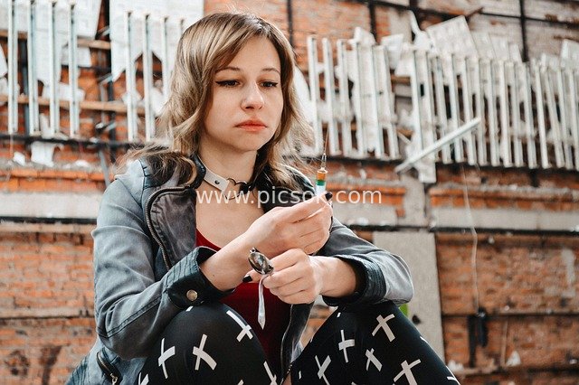 Punk Woman Holding a Syringe: A Documentary Scene of Drug Addiction