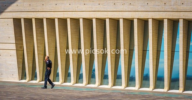 A Security Guard Smoking in Front of Modern Architecture in Santa Cruz de Tenerife