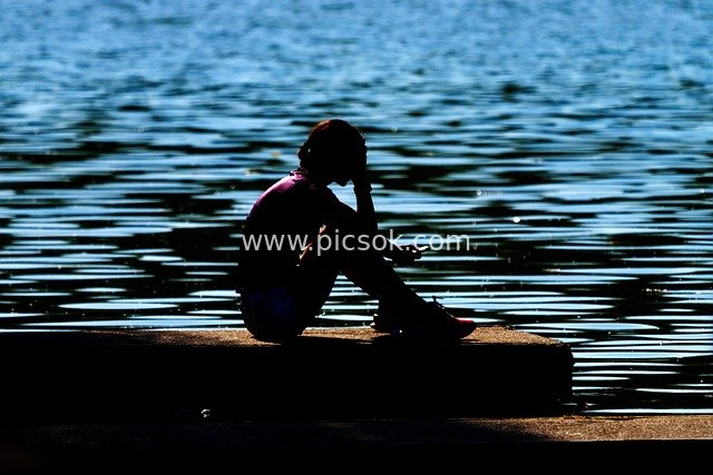 Silhouette of a Girl Using Her Phone by the Lake: A Serene Natural Relaxation Moment