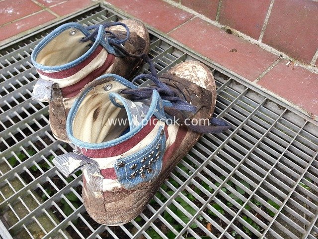 Close-up of Old High-Top Sneakers Covered in Mud