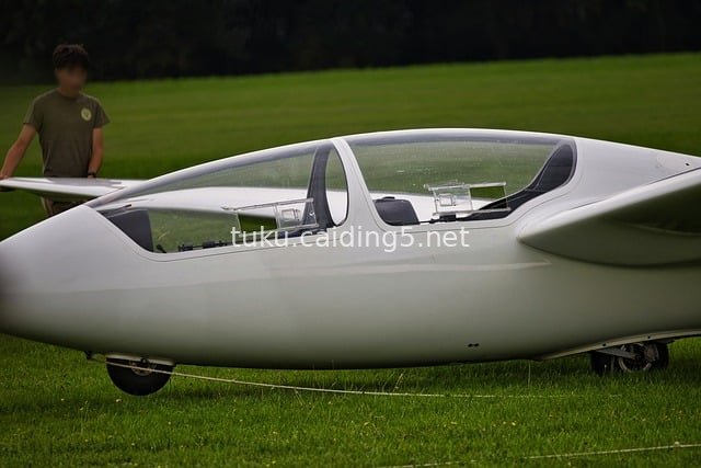 White Glider Resting on Lush Green Grass – Outdoor Aviation Scene