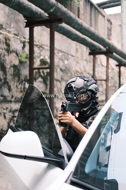 男孩持玩具枪模拟战术 白色汽车旁场景