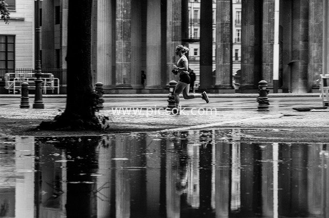 Dynamic Black-and-White Moment of a Woman Jogging at City Square in the Morning