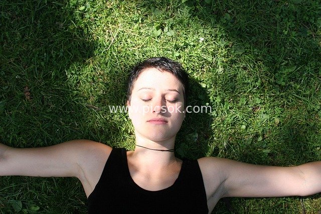 草地冥想放松的短发女子 自然禅意生活场景