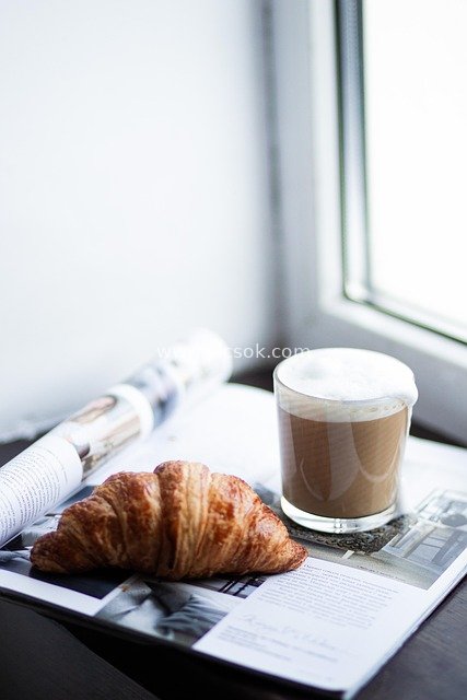 Cozy Good Morning Scene: Breakfast, Cappuccino, Croissant, Book, Gift & News by the Window