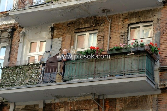 城市老旧红砖楼阳台 老人放松的生活瞬间