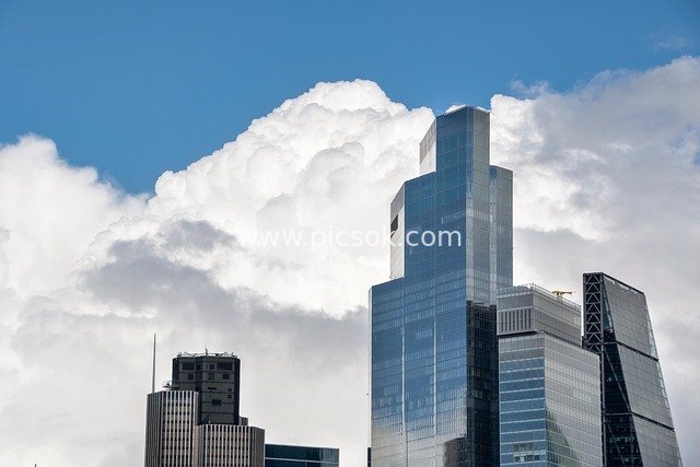 London Urban Skyline: Modern Glass Buildings Under Storm Clouds