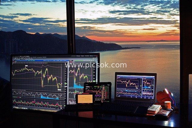 Financial Trading Equipment and Charts Against a Seaside Sunrise