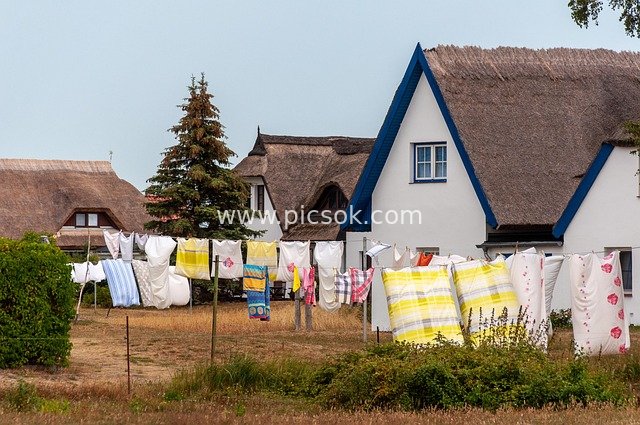 Cozy Scene of Colorful Clothes Drying in Front of Rural Thatched Cottages