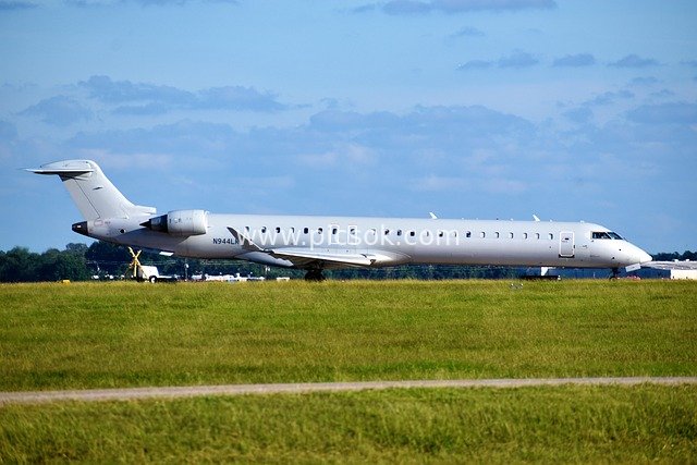 White Jet Parked on Airport Grass – Real Shot of Air Transport
