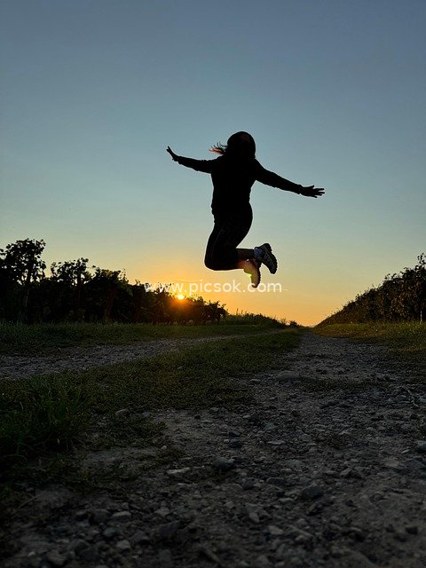 Woman Jumping at Sunset, Savoring a Joyful Life Moment