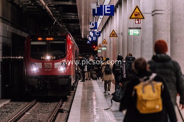 Busy Urban Subway Station Scene Featuring Red DB Regional Train and Traveling Passengers
