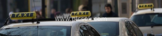 城市街道上的黄色TAXI出租车标志与车辆