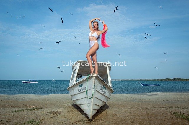Fashion Photoshoot of Bikini Model by White Boat on Tropical Beach with Blue Sky, Flying Birds & Seaview