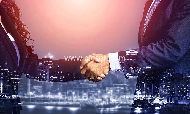 Business Handshake at Urban Nightscape: Moment of Corporate Partnership Agreement Reached