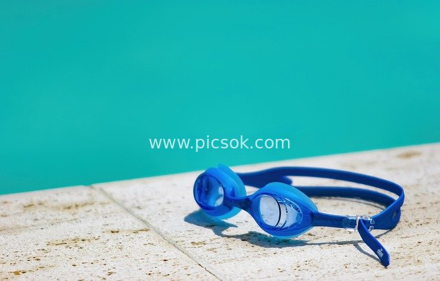 夏日泳池边蓝色泳镜 休闲游泳放松场景