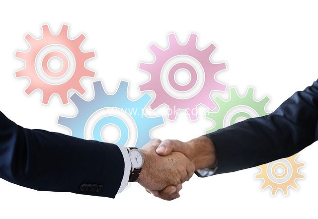 Business Professionals Shaking Hands in Partnership, Colorful Gears Symbolizing Team Collaboration
