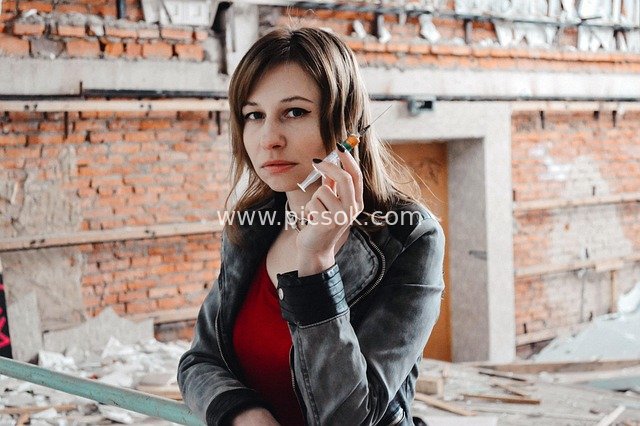 Woman with Syringe in Abandoned Factory: Dangerous Scene of Drug Addiction