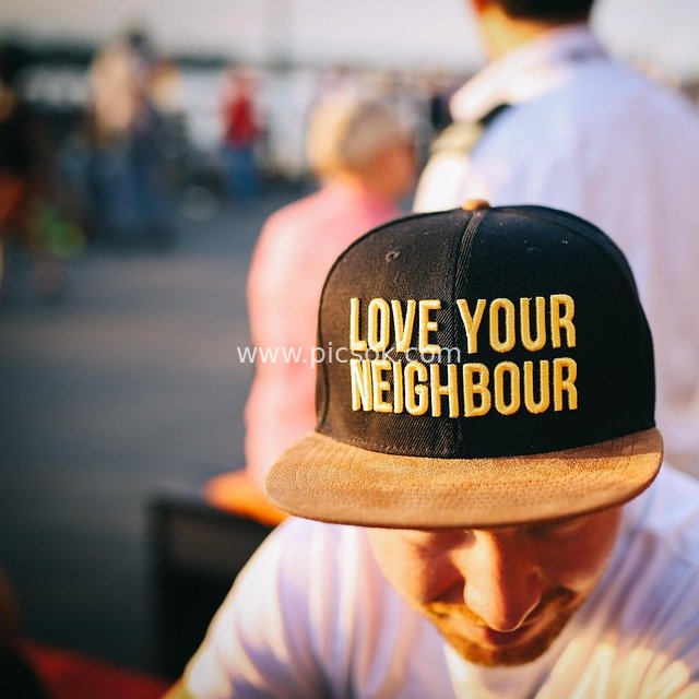 'Love Your Neighbour' Slogan Cap in a Warm Outdoor Life Scene