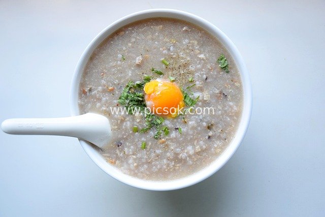 Fragrant Soft-Boiled Egg Porridge with Coriander - Heartwarming Breakfast in a White Porcelain Bowl