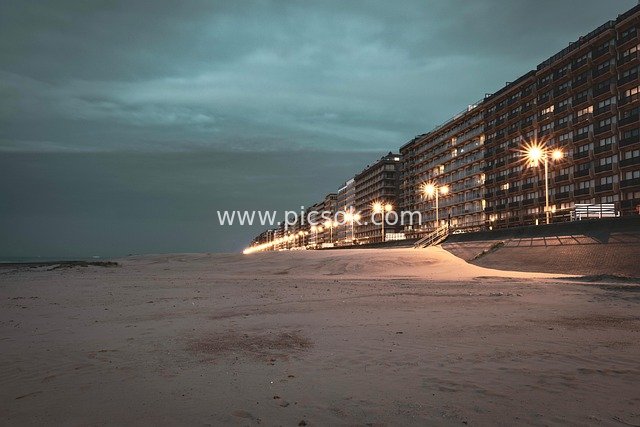 Warm-Lit Night View of Coastal Architectural Complex by the Beach