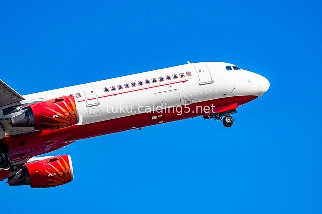 红白涂装民航客机蓝天翱翔高清图