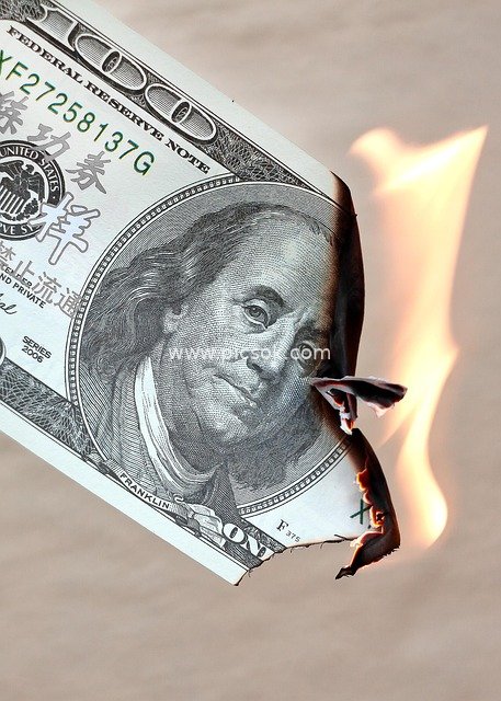 Burning $100 Bill: Warning of Economic Risks and Currency Devaluation