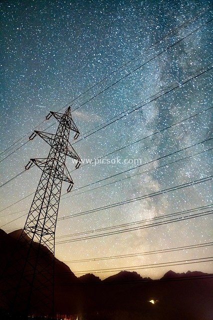 Night View of Transmission Towers and Wires Under the Milky Way Galaxy