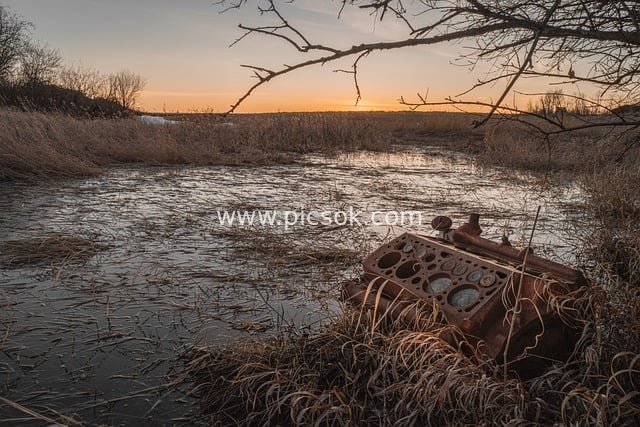 Vintage Scene of Abandoned Rusty V8 Engine at Wetland Sunset