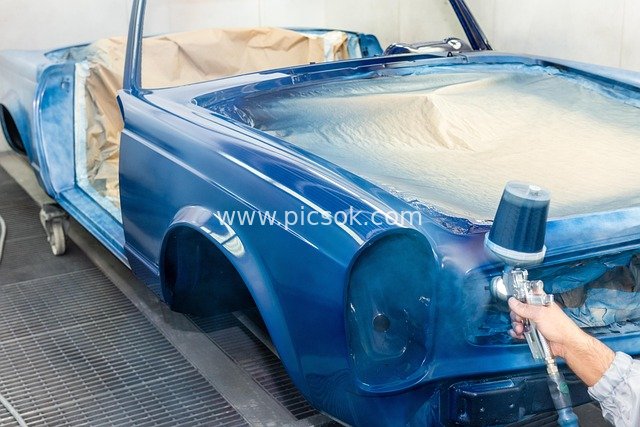Vintage Car Paint Restoration: Professional Spray Gun Operation Scene