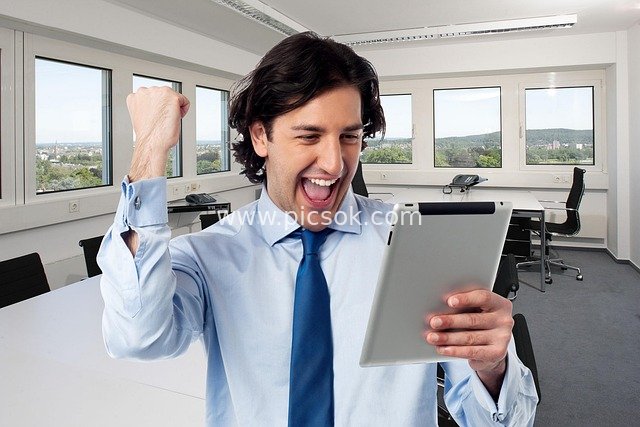 Successful Business Professional Joyfully Celebrating with Tablet in Office