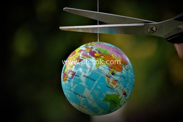 剪刀欲剪悬挂地球仪 地球危机隐喻图