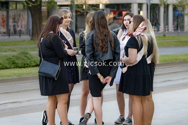 Group of Young Women Chatting Relaxedly by Urban Tram Station