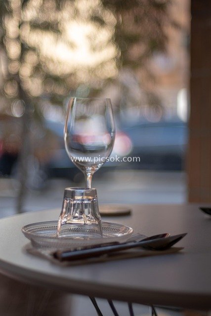 咖啡馆户外餐桌的精致餐具与酒杯特写