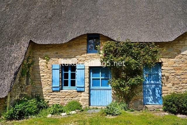 传统茅草石屋 蓝门窗复古乡村建筑风貌