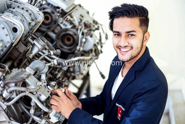 Young Mechanic Smiling While Inspecting and Repairing an Engine - Professional Workplace Scene