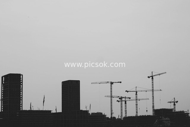 Urban Construction Scene: Black and White Silhouettes of Tower Cranes and Unfinished High-Rises
