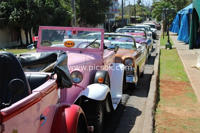 Bustling Street Queue of Colorful Vintage Convertibles at a Market