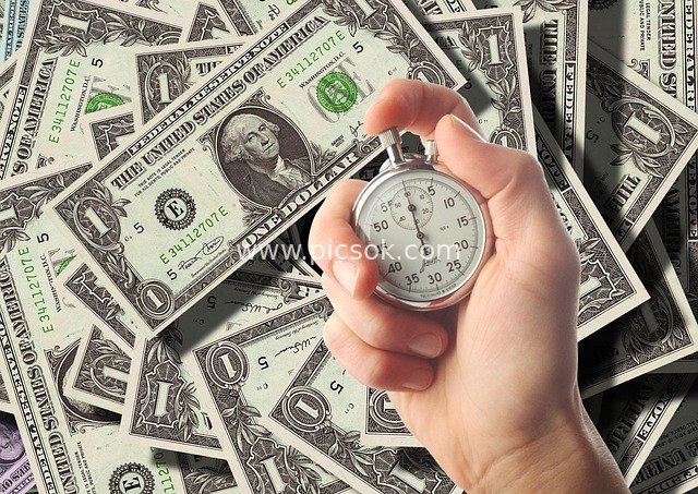Stopwatch Held with Dollars: Business Imagery of Time and Financial Wealth