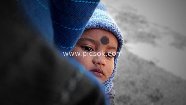 Close-Up Portrait of a Child in a Blue Beanie, Gazing Intently in Winter
