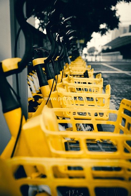 街头整齐排列的黄色共享自行车出行场景