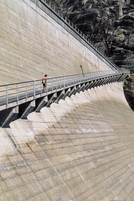 Majestic Scene of Alpine Gravity Dam Project with a Hiker