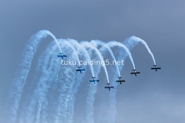 Swansea Airshow: Team Raven Aerobatic Team Displays Grace with Blue-White Smoke Trails