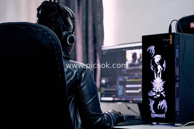 Professional Video Editor Wearing Headphones Focused on Computer Creation