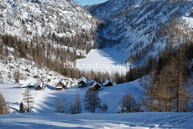 冬日雪山下的静谧木屋村落风景