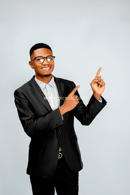 Elegant Man in Black Suit Pointing Sideways - White Background Advertising Material